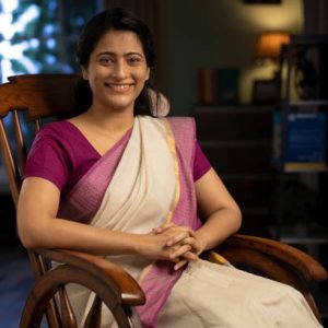 Shot of a woman in sari sitting on a rocking chair at home